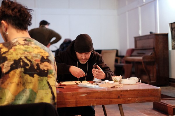 A man wearing a beanie at a desk.