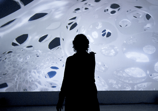 A silhouette of person in front of a white, mushroom structure.