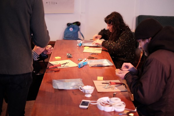 People at a desk tinkering with tools.