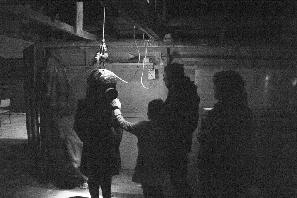A group of people in a dark room with someone wearing the diving helmet.