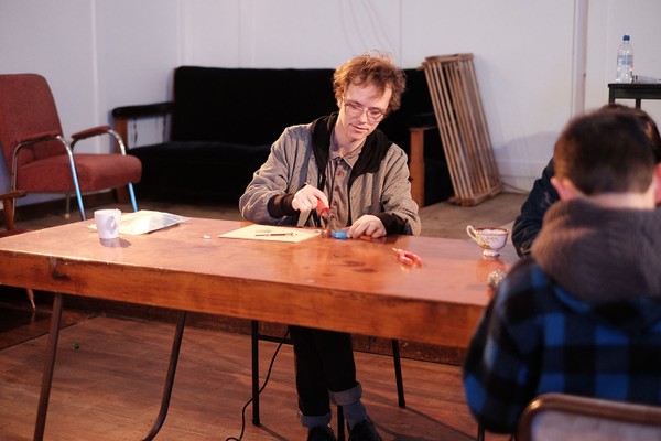 A man wearing glasses at a desk.