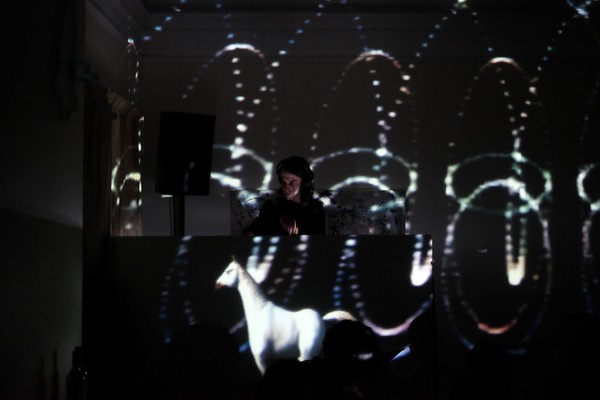 Someone playing music with light projections around a room.